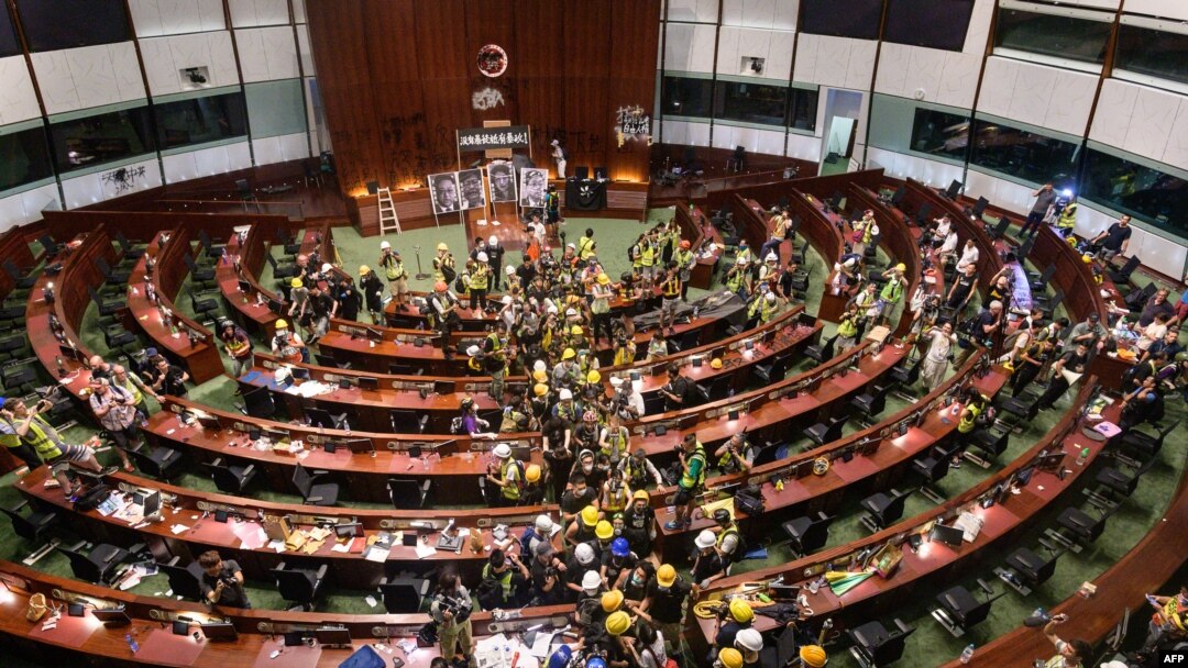 Sejumlah demonstran bergerak keluar dari ruang utama geduing pemerintahan Hong Kong dalam aksi protes pada 2 Juli 2019. (Foto: AFP/Anthony Wallace)