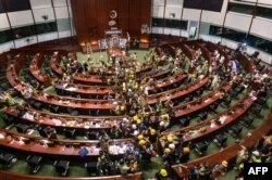 Para pengunjuk rasa meninggalkan ruang utama kantor pusat pemerintah di Hong Kong pada awal 2 Juli 2019. (Foto: AFP)