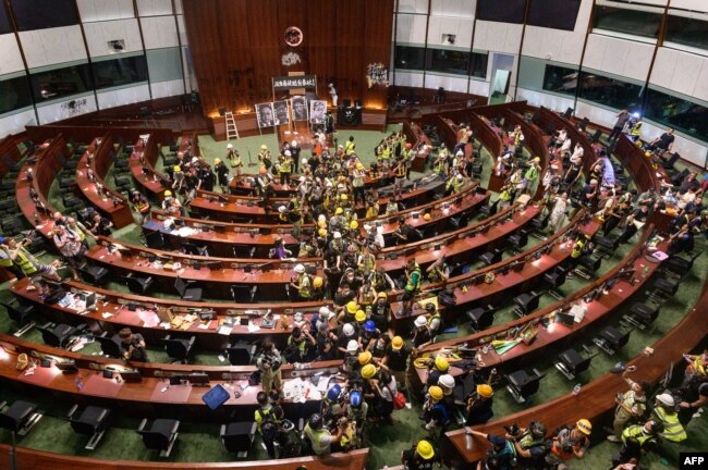 Para pengunjuk rasa meninggalkan ruang utama kantor pusat pemerintah di Hong Kong pada awal 2 Juli 2019. (Foto: AFP)