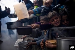 Warga Palestina antre untuk mendapatkan makan di Rafah, Jalur Gaza, Jumat, 16 Februari 2024. (Foto: AP)