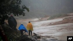 Sejumlah warga melintas di jalan yang tertutup longsoran tanah akibat Badai Eta diSan Cristobal Verapaz, Guatemala, 7 November 2020.