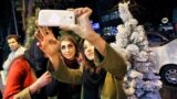 چند خانم جوان ایرانی در تهران، در کنار یک درخت کریسمس، عکس یادگاری می گیرند.<br />
عکس: عبدالله حیدری، ایرنا
