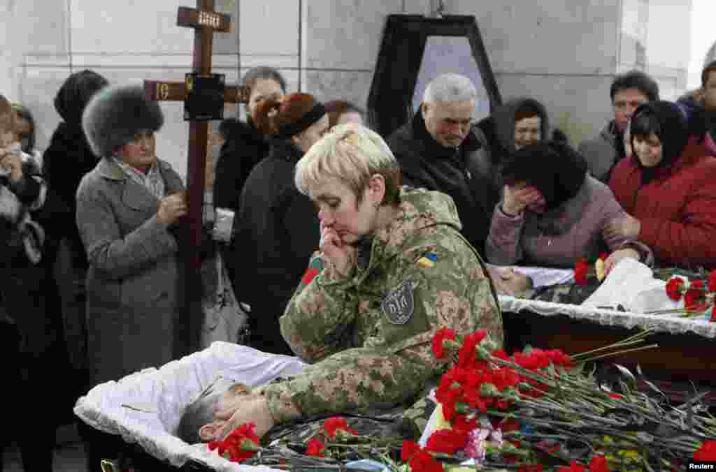 People mourn during a funeral ceremony for Ruslan Boburov and Vadym Zherebylo, members of the self-defense battalion &quot;Aydar,&quot; who were killed while fighting in eastern Ukraine, Feb. 2, 2015.