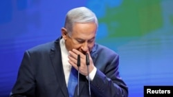 Benjamin Netanyahu, umushikiranganji wa mbere wa Isirayeli ariko arakorora mugihe yariko ashikiriza ijambo mu nama yahariwe amagara i Tel Aviv, Isirayeli, Itariki 27/03/2018. 