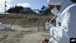 A handout picture released by Greenpeace and taken on March 27, 2011 shows Greenpeace members monitoring contamination levels at Iitate village, 40 km northwest of the crisis-stricken Fukushima nuclear plant, and 20 km beyond the official evacuation zone.