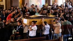 Men carry the coffin of a victim during the funeral for those killed in a Palm Sunday church attack in Alexandria Egypt, at the Mar Amina church, April 10, 2017. 