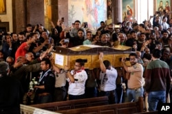 Men carry the coffin of a victim during the funeral for those killed in a Palm Sunday church attack in Alexandria Egypt, at the Mar Amina church, April 10, 2017.