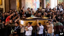 Men carry the coffin of a victim during the funeral for those killed in a Palm Sunday church attack in Alexandria Egypt, at the Mar Amina church, April 10, 2017. 