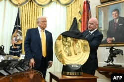 El presidente de Estados Unidos, Donald Trump, observa mientras el presidente de la FIFA, Gianni Infantino, presenta el nuevo trofeo de la Copa Mundial de Clubes de la FIFA en la Oficina Oval de la Casa Blanca, en Washington, DC, el 7 de marzo de 2025. (Foto de Jim WATSON / AFP)