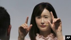 Un prototipo de la empresa electrónica japonesa Toshiba, la androide 'Señorita Aiko Chihira' interpreta lenguaje por senas a un visitante de la exhibicion CEATEC de tecnologia avanzada, en Chiba, Japon, 7/10/14. 