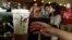 FILE - A customer reaches out for a Starbucks beverage at the new Starbucks coffee store in San Jose, Costa Rica, June 20, 2012. 