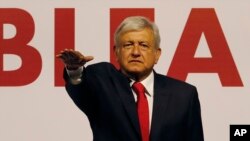 Andres Manuel Lopez Obrador holds his hand out to take an oath as he is named the presidential candidate for the MORENA political party in Mexico City, Feb. 18, 2018. 