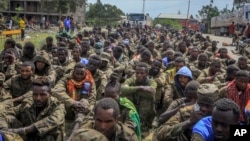 FILE - Captured Ethiopian government soldiers and allied militia members sit in rows after being paraded by Tigray forces through the streets in open-top trucks, as they arrived to be taken to a detention center in Mekele, the capital of the Tigray region