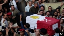 FILE - Egyptians carry the coffin of 1st Lt. Mohammed Adel Abdel Azeem, killed in an attack by Islamic militants in the Sinai, during the funeral procession at his home village of Tant Al Jazeera in Qalubiyah, north of Cairo, July 2, 2015.