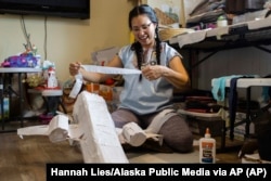 In this photo provided by Alaska Public Media, Carolina Tolladay Vadal is shown making a piñata in her home in Anchorage, Alaska, on April 14, 2021