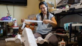In this photo provided by Alaska Public Media, Carolina Tolladay Vadal is shown making a piñata in her home in Anchorage, Alaska, on April 14, 2021