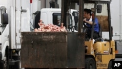 A worker operates a forklift, carrying a container loaded with a pile of bones of beef, at a wholesale meat market in Tokyo, July 12, 2011