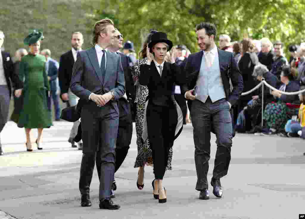 Cara Delevingne, center, arrives ahead of the wedding of Princess Eugenie of York and Jack Brooksbank at St George’s Chapel, Windsor Castle, near London.