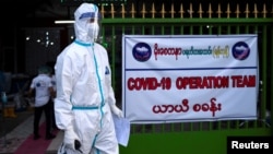 A volunteer wearing a protective suit stands as he waits to transfer suspect cases to a quarantine center amid the outbreak of the coronavirus diseases (COVID-19), in Yangon, Myanmar, October 3, 2020. Picture taken October 3, 2020. REUTERS/Shwe Paw Mya Ti