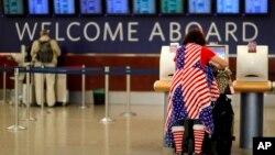 亚特兰大国际机场的出港大厅，一名旅客正在办理值机手续。（资料照片，2017年11月22日）