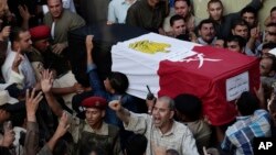 FILE - Egyptians carry the coffin of 1st Lt. Mohammed Adel Abdel Azeem, killed in an attack by Islamic militants in the Sinai Peninsula, during the funeral procession at his home village of Tant Al Jazeera in Qalubiyah, north of Cairo, July 2, 2015.