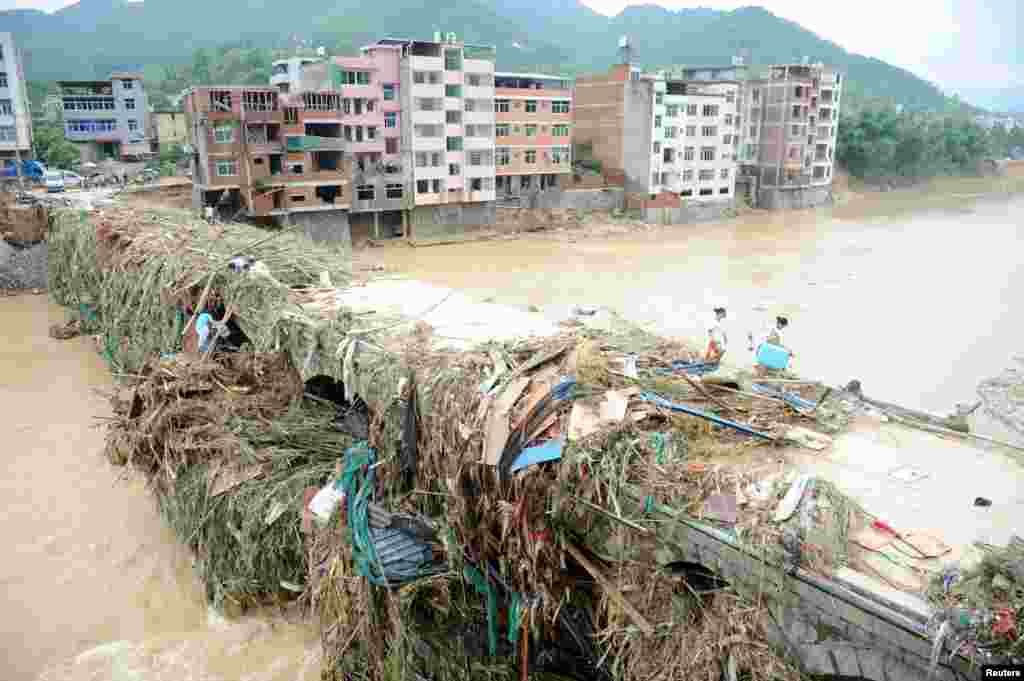 Residents walk on a bridge surveying damge caused by Typhoon Nepartak, in Fuzhou, Fujian Province, China, July 11, 2016.