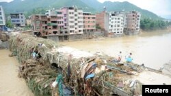 Warga berjalan di atas jembatan di Fuzhou, provinsi Fujian, China, setelah topan Nepartak melanda daerah itu (11/7). 