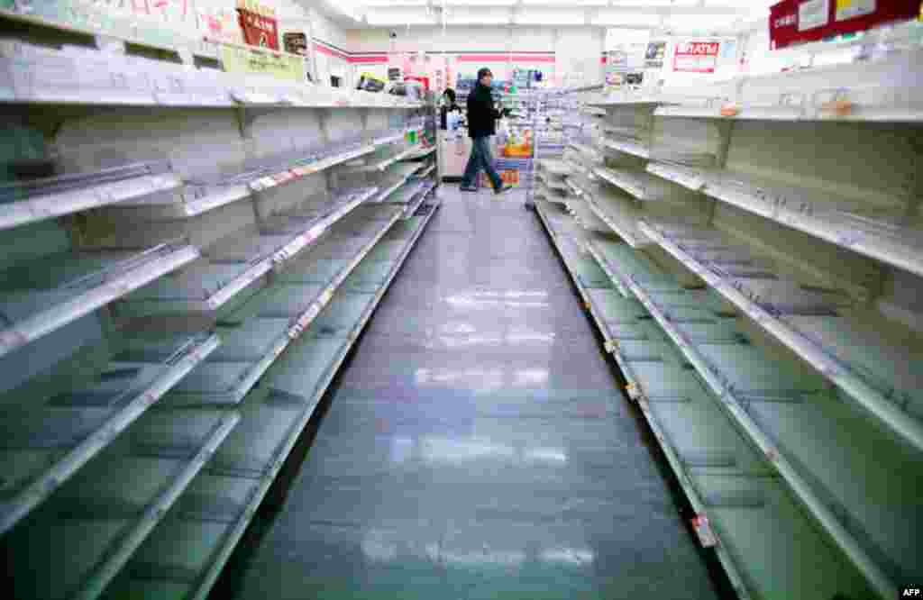 A man shops in a convenience store on Tuesday, where shelves on food aisles are left empty in Ofunato, northern Japan. (AP)