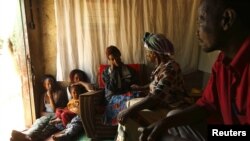 Rosina Mwitelela (nomor dua dari kanan) mengunjungi pasien HIV-AIDS (tengah) di rumahnya di Matero, Lusaka (17/4). Pakar kesehatan mendapat tantangan baru untuk mempersiapkan kehidupan bagi para penderita HIV-AIDS di masa depan.