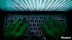 FILE - A man types on a computer keyboard, in this illustration photo. Chinese hackers might have held access for months to network infrastructure used by companies to cooperate with court-authorized U.S. requests for communications data, the Wall Street Journal says. 