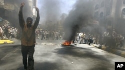 An anti-government protester flashes the victory sign during a demonstration to demand the ouster of Yemen's President Ali Abdullah Saleh in the southern city of Taiz May 12, 2011.