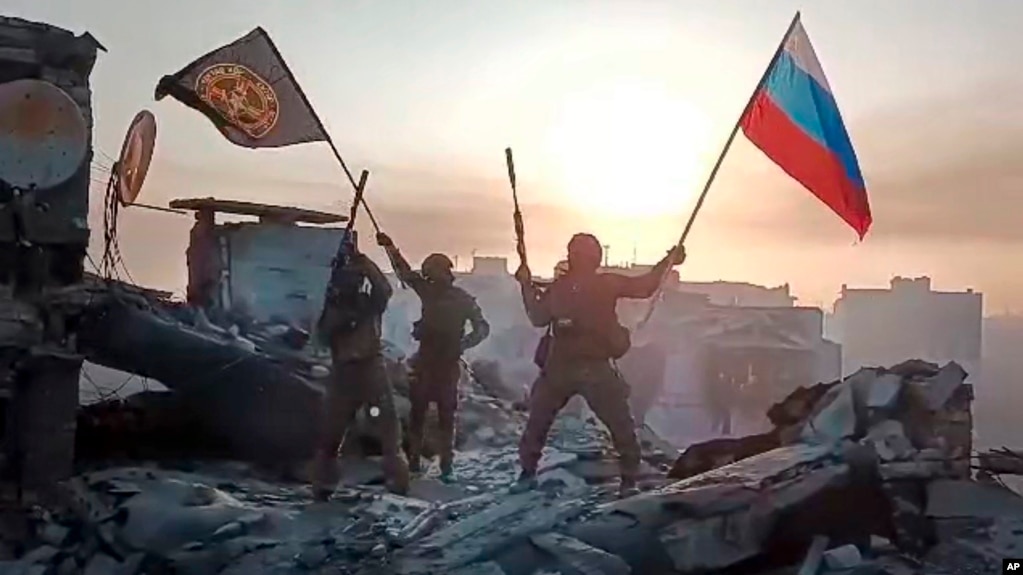 ARCHIVO: Captura de pantalla de un video de miembros del Grupo Wagner celebrando en el tejado de un edificio dañado en Bájmut, Ucrania, el 20 de mayo de 2023.