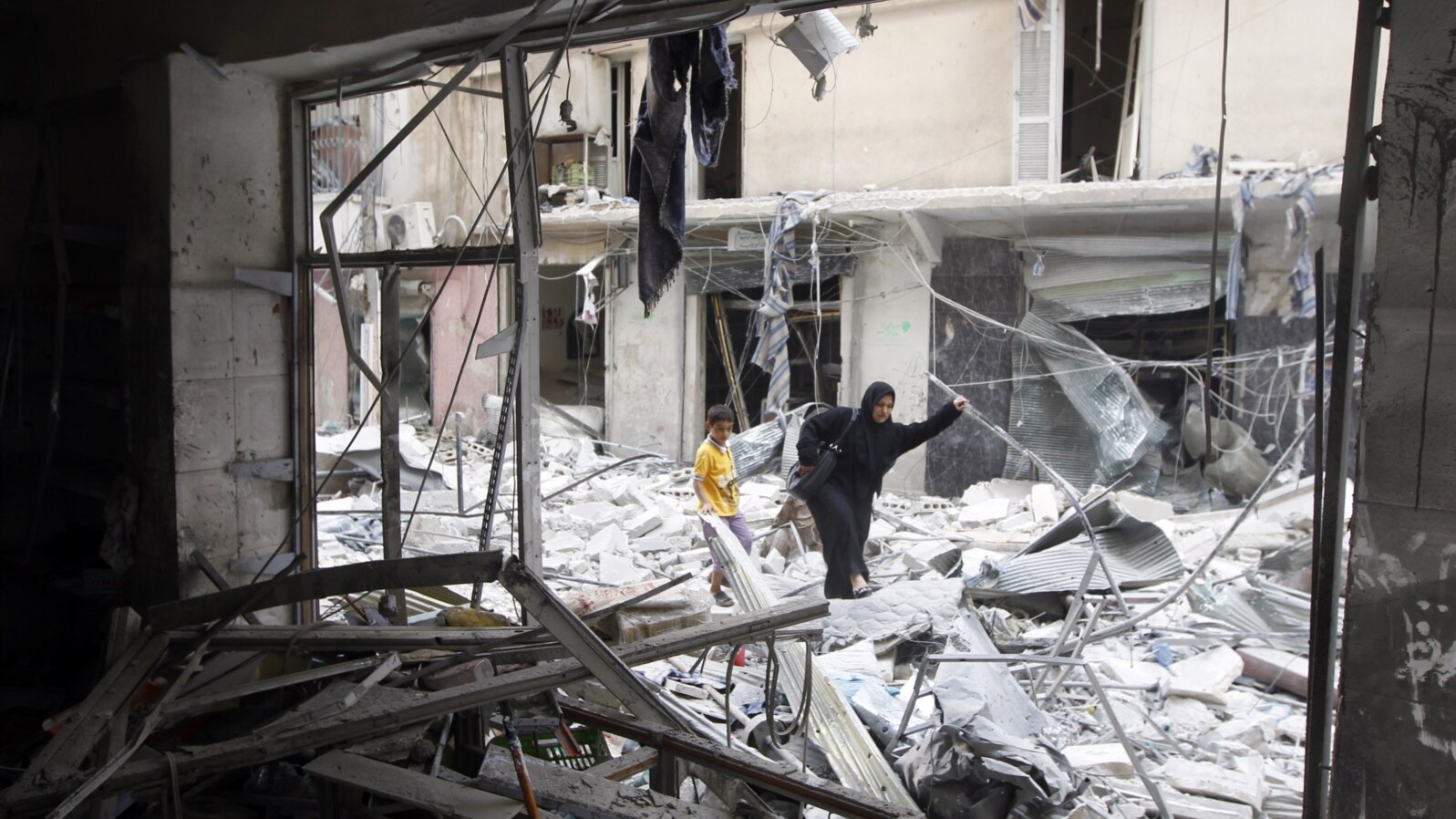 A woman walks through rubble from a building destroyed by shelling from forces loyal to Syrian President Bashar Al-Assad in downtown Aleppo August 1, 2012.