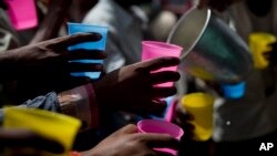 FILE - Indians reach for a cold drink being freely distributed on a hot summer day in New Delhi, India, June 5, 2017. Most parts of northern India are experiencing intense heat wave conditions with the temperature crossing 43 degrees Celsius (109.4 Fahrenheit).