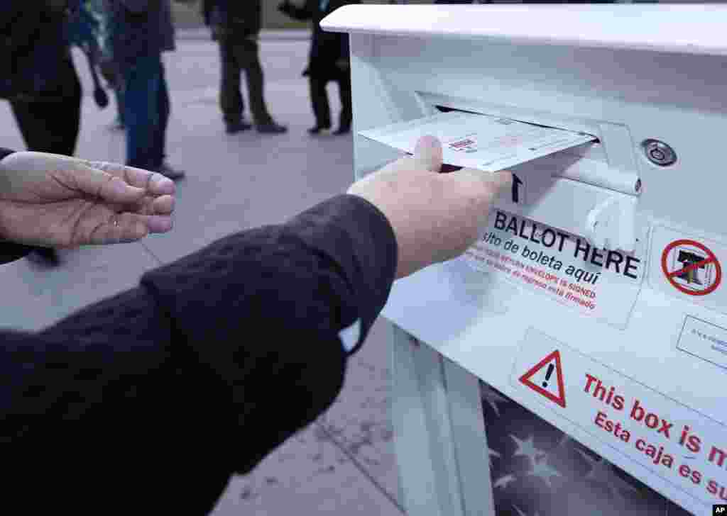 A voter places a ballot in a drop box outside the Denver Elections Division headquarters, Nov. 8, 2022, in downtown Denver, Colorado.