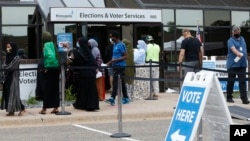 FILE - Voters, among them Somali Americans, line up to cast their ballots in primary elections, at the Minneapolis Election and Voters Services offices, in Minneapolis, Minnesota, Aug. 10, 2020.