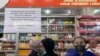 Karyawan menunggu pelanggan di loket yang menampilkan pemberitahuan penghentian sementara penjualan sirup obat di apotek di Jakarta, Kamis, 20 Oktober 2022. (AP/Tatan Syuflana)