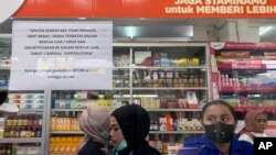 Karyawan menunggu pelanggan di loket yang menampilkan pemberitahuan penghentian sementara penjualan sirup obat di apotek di Jakarta, Kamis, 20 Oktober 2022. (AP/Tatan Syuflana)