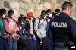 Para migran turun dari kapal kemanusiaan Jerman Rise Above berlabuh di kota pelabuhan Italia selatan Reggio Calabria, Selasa, 8 November 2022. (AP/Valeria Ferraro)