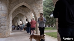 Nali and her owner, Nick Edinger, line up at Austin Oaks Church during the U.S. midterm elections in Austin, Texas, Nov. 8, 2022. (REUTERS/Nuri Vallbona)