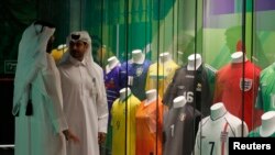 Pengunjung berdiri di samping kaus para pemain sepak bola yang dipajang di 3-2-1 Qatar Museum Olimpiade dan Olahraga, 10 Oktober 2022. REUTERS/Hamad I Mohammed