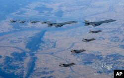 Dua pembom B-1B Angkatan Udara A.S., tengah atas, empat jet tempur F-35 Angkatan Udara Korea Selatan dan empat jet tempur F-16 Angkatan Udara AS terbang di atas Semenanjung Korea Selatan selama latihan udara bersama yang disebut "Vigilant Storm," di Selatan Korea, Sabtu, 5 November 2022. (Foto: via AP)