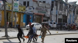 FILE - An injured civilian is evacuated from the scene of an explosion in Mogadishu, Somalia, Oct. 29, 2022. Al-Shabab claimed responsibility for the attack, as well as a Saturday suicide bombing targeting a military training facility in Mogadishu.