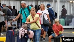 Passengers push their baggage after their Kenya Airways flight was cancelled during a strike of Kenya Airways pilots at the Jomo Kenyatta International Airport in Nairobi, Nov. 7, 2022. 