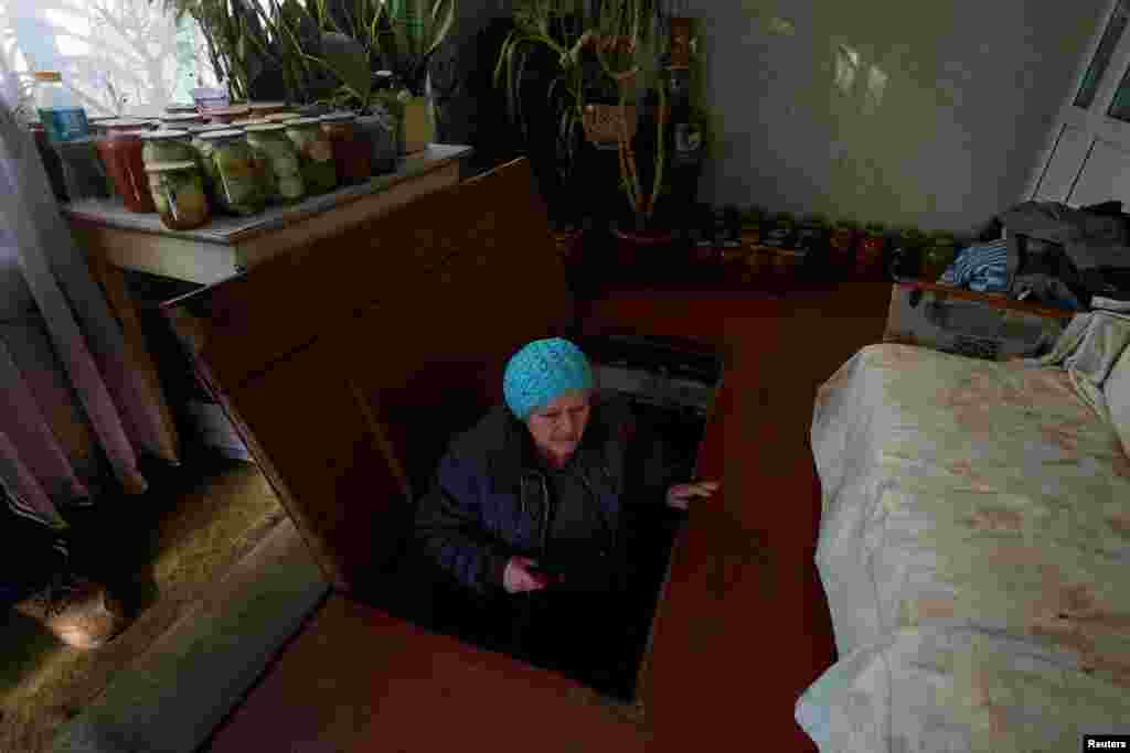Nataliia Chopova, 69, comes out of a shelter where she and her husband Oleksandr live during nights since July 12, amid constant Russian military attacks in the town of Nikopol, Dnipropetrovsk region, Ukraine, Nov. 7, 2022.
