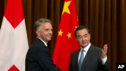 瑞士聯邦委員（Swiss Federal Councillo）迪迪埃·伯克哈爾特（Didier Burkhalter）2013年4月25日在北京舉行會談前同中國外長王毅握手拍照。