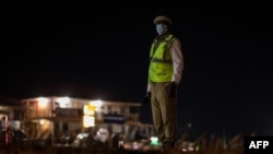FILE: A Ugandan police officer patrol at night, following a presidential directive to impose curfew and lockdown in the districts of Mubende and Kasanda to curb the spread of Ebola virus. (AFP)