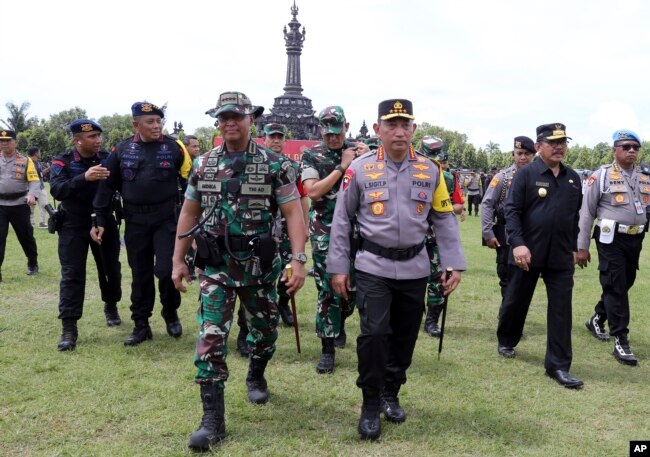 Dari depan; Kapolri Listyo Sigit Prabowo (kanan) bersama Kapolri Andika Perkasa (kiri), saat berlangsungnya parade keamanan menjelang pertemuan G20 di Bali, Senin, 7 November 2022. (AP/Firdia Lisnawati)