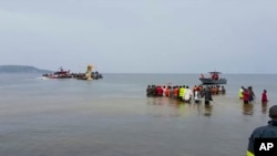 Equipas de salvamento e residentes tentam resgatar passageiros de avião que caiu no Lago Vitória, Tanzânia, 6 Novembro 2022
