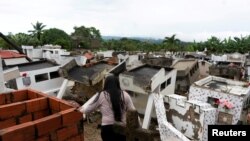 Una mujer mira los escombros de un cementerio destruido después de horas de fuertes lluvias que, según las autoridades, provocaron un deslizamiento de tierra por una falla geológica en Piojo, Colombia, el 6 de noviembre de 2022.